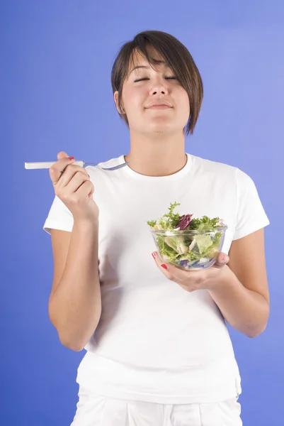 Donna che mangia un'insalata verde — Foto Stock