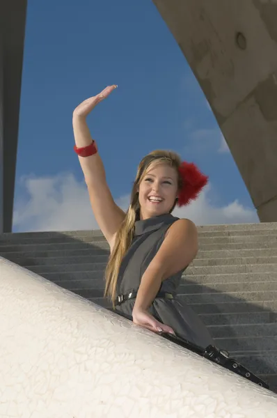 Jeune femme sur un escalier agitant — Photo