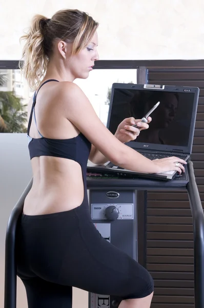 Woman doing exercise and working with lap top — Stock Photo, Image