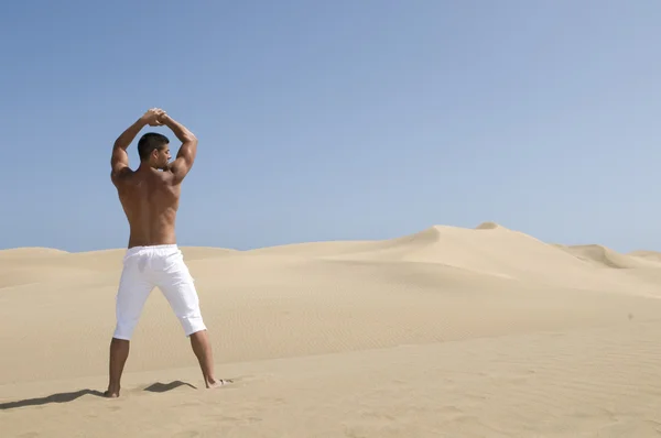 Hombre musculoso en las dunas del desierto — Foto de Stock