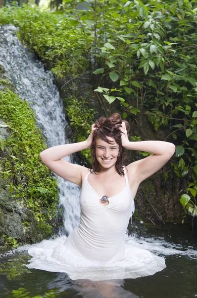 Femme heureuse dans une cascade — Photo