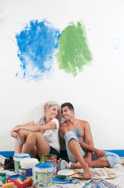 Casal cansado depois de pintar em casa — Fotografia de Stock
