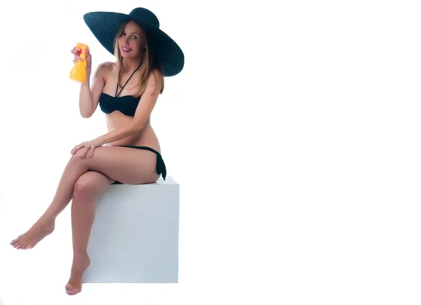 Meisje in zwarte bikini holding spray fles — Stockfoto