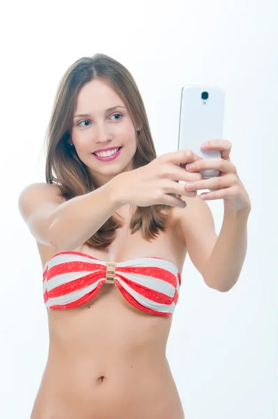 Mooie vrouw in bikini nemen foto op haar telefoon — Stockfoto