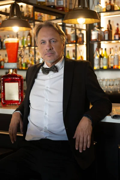 Attractive mature man in tuxedo inside a pub