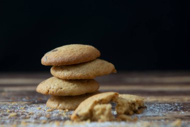 Koyu bir ahşap masaya istiflenmiş kurabiye dağı.