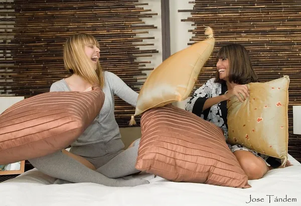 枕の上で遊んでいる2人の女性が — ストック写真