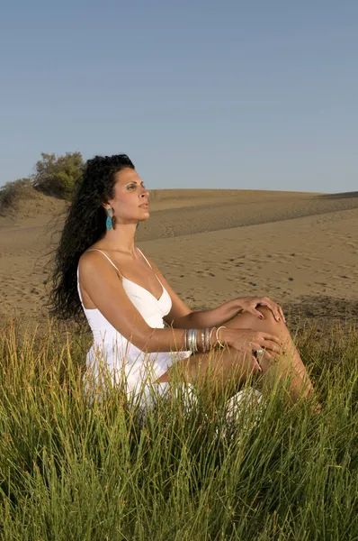 白い服を着た春や夏の太陽を楽しむ砂の上の女性 — ストック写真