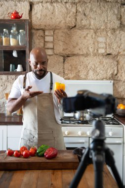 Afro-Amerikalı adam mutfağında internet kanalı için yayın yapıyor.