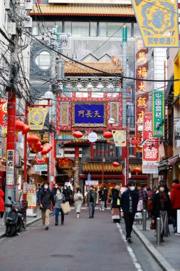 Yokohama, Japonya - Şubat 06 2022: Yokohama 'daki Çin Mahallesi' nin Tenchomon Kapısı yakınında yürüyen yayalar. Burası Japonya 'nın en büyük Çin Mahallesi. Dar ve renkli caddelerde birçok mağazası ve restoranı var..