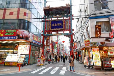 Yokohama, Japonya - Şubat 06 2022: Yokohama 'daki Çin Mahallesi' nin Tenchomon Kapısı yakınında yürüyen yayalar. Burası Japonya 'nın en büyük Çin Mahallesi. Dar ve renkli caddelerde birçok mağazası ve restoranı var..