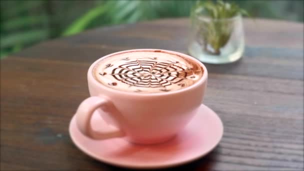 Primo piano della tazza di caffè rosa caldo in ceramica sul piattino con cioccolato Latte Art — Video Stock