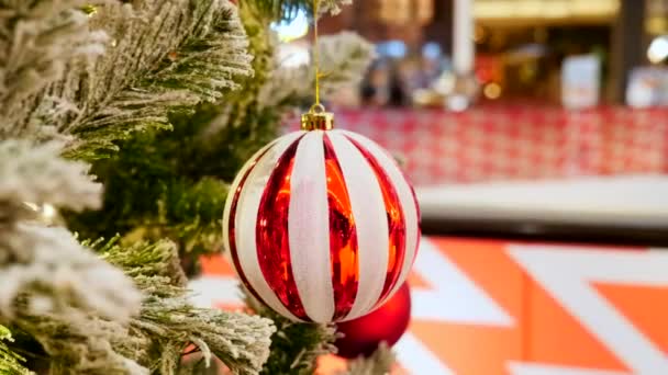 Bola de Navidad en el árbol en el centro comercial con gente borrosa en el fondo — Vídeos de Stock