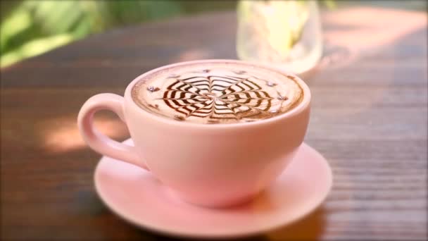 用巧克力拿铁艺术在茶托上制作热陶瓷粉红咖啡杯特写 — 图库视频影像