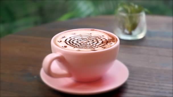Närbild av varma keramiska rosa kaffe Cup på tefat med choklad Latte konst — Stockvideo