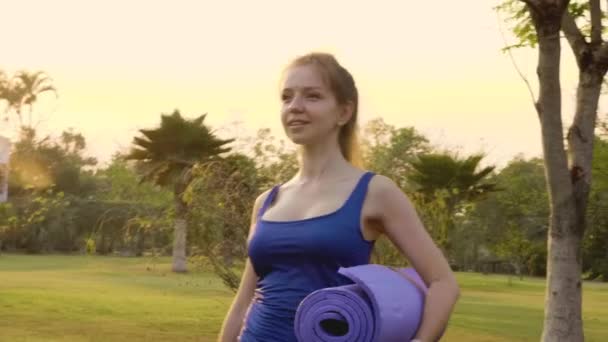 Fitness Vrouw met Yoga Mat Wandelen op Training in Public Park in Sunset — Stockvideo