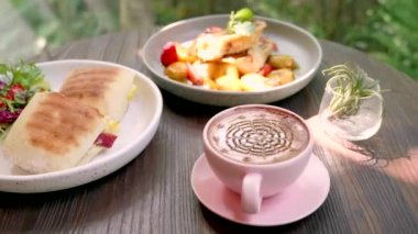 Bir fincan kahve, yumurtalı sandviç, peynir, pastırma, salata ve muzlu tost.