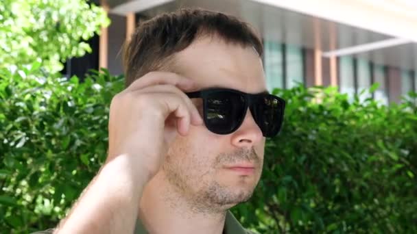 Man verwijdert zwarte spiegel zonnebril, Show Eye met ontsteking, half geopende oog — Stockvideo