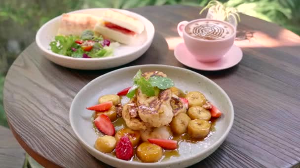 Lunch i mysiga Tropical Cafe - rostat bröd med frukt, smörgås och kaffe — Stockvideo