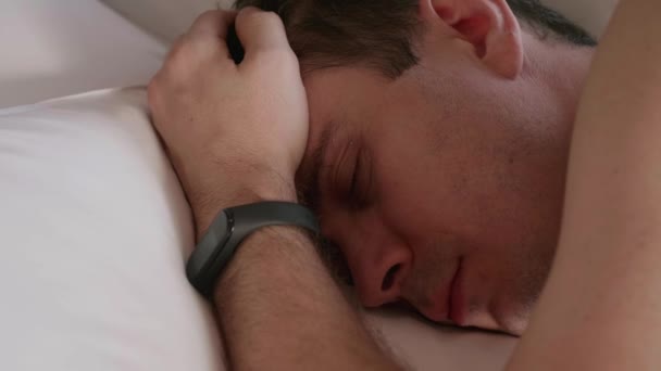 Çıplak vücutlu yorgun adam evde yatakta yatıyor ve yorucu bir günün ardından dinleniyor. — Stok video