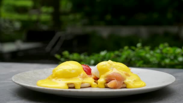 Delicious breakfast with eggs benedict with smoked salmon in outdoor restaurant — Stock Video