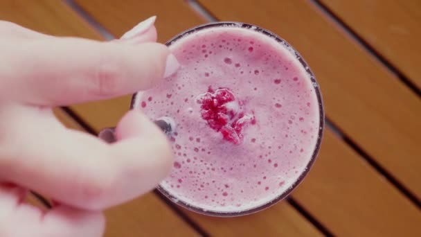 Bardakta Ahududu Smoothie. Kadın Eli Taze Pembe Böğürtlen İçeceğini Tazeledi — Stok video