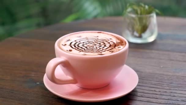 Kaffeetasse und dekorative tropische Pflanze im Glas auf Restauranttisch, Sonnenlicht — Stockvideo