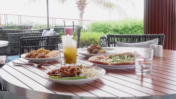 Comida e refeições em férias em um resort tropical. Pizza italiana, massas e bebidas — Vídeo de Stock