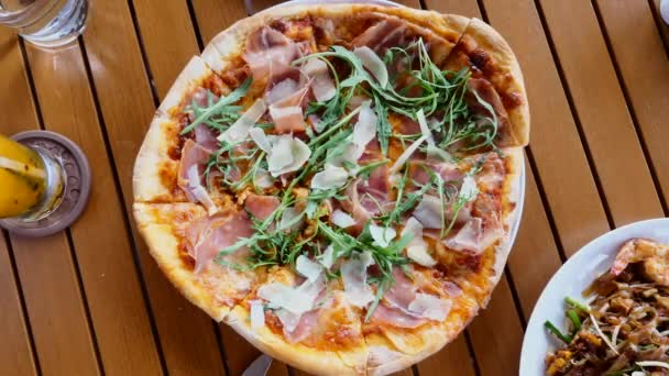 Mann nimmt eine Scheibe frisch gebackene Pizza mit Parmesan, Prosciutto — Stockvideo