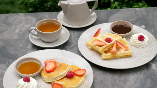 Сладкий завтрак в отеле. Американские блинчики со свежими ягодами и вафлями — стоковое видео