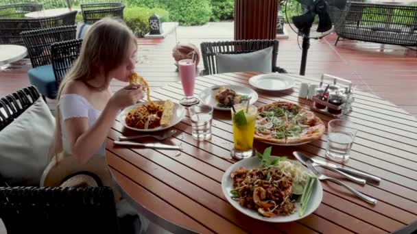 Attractive woman eats italian pasta in outdoor restaurant or cafe, prepared food — Stock Video