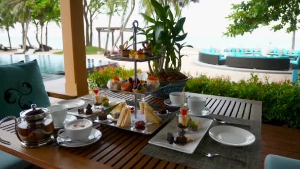 Tè pomeridiano in vacanza in hotel di lusso vicino al mare. Cibo dolce con torte — Video Stock