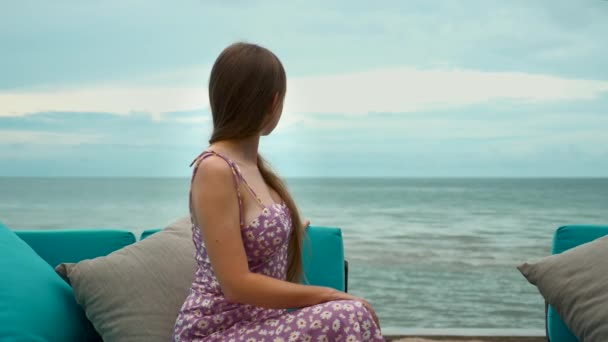Vacances d'été en mer. Voyage femme s'assied sur le canapé sur la plage et profiter de l'océan — Video