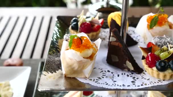 Woman eating various desserts in cafe - cakes, macaroons, tarts with berries — Stock Video