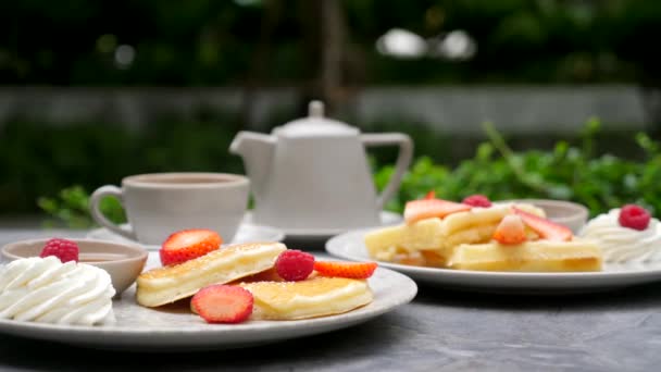Чай с блинами и вафлями со свежей клубникой, малиной, кленовым соусом — стоковое видео