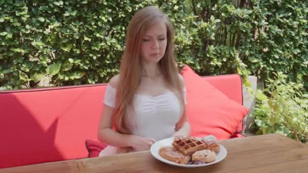 Sovány fiatal nő a fogyókúra agresszíven visszautasítja, hogy enni édes süteményt, pékség — Stock videók