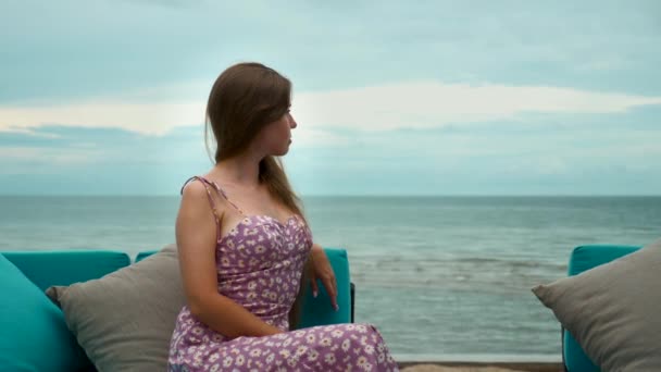 Aantrekkelijke eenzame, attente vrouw die alleen op het strand zit, verdrietig, denk aan de toekomst — Stockvideo