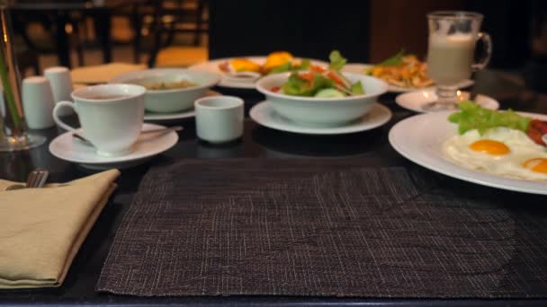 A pincér ételt szolgál fel vacsorára az étteremben, a férfi kéz tányért tesz az asztalra. — Stock videók