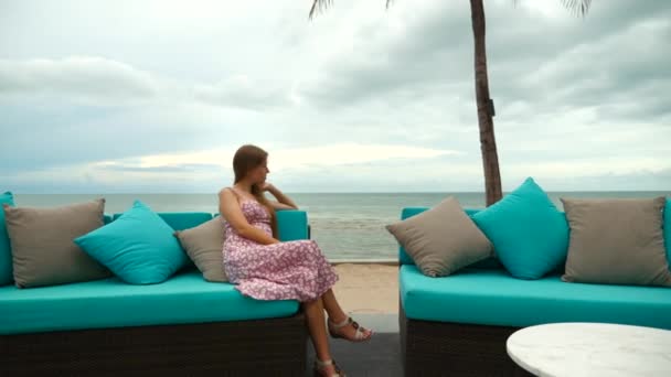 魅力的な孤独、思慮深い女性だけでビーチに座って、悲しい、将来を考える — ストック動画