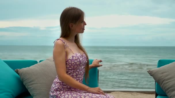 Samotna kobieta podróżująca zrelaksować się na plaży, cieszyć się oceanem, wstaje z kanapy i wychodzi — Wideo stockowe