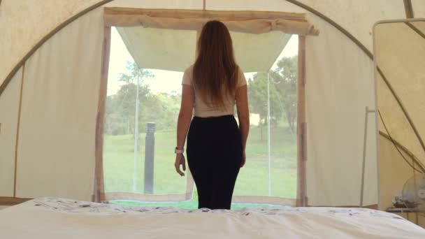 Viajar acampar mulher caminha para fora da tenda para ver sobre a natureza e animais selvagens — Vídeo de Stock