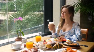 Restoranda ya da kafede kahve bardağıyla mutlu bir kadın, otelde kahvaltı, tatil köyü.