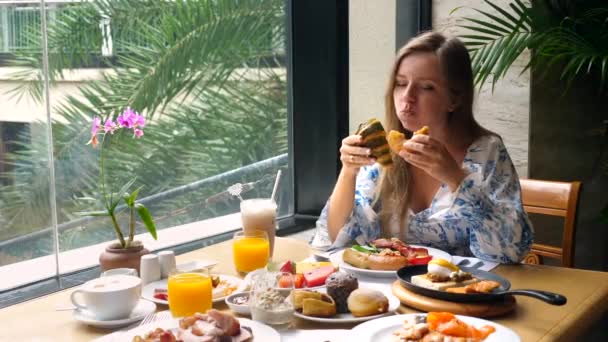 Ανθυγιεινή διατροφή. Ευτυχισμένη πεινασμένη γυναίκα άπληστα τρώει νόστιμο φρέσκο αρτοποιείο, μη διατροφή — Αρχείο Βίντεο