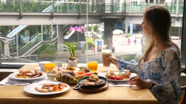 Сучасна жінка-бізнесмен їсть сніданок у міському кафе з зайнятим міським життям — стокове відео