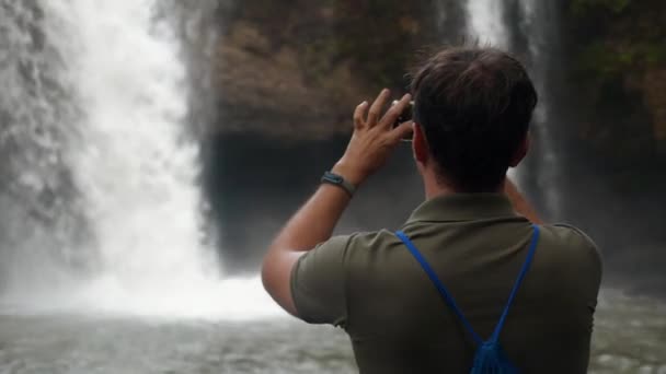 Pengaruh media sosial orang atau pembuat konten pria menembak air terjun — Stok Video