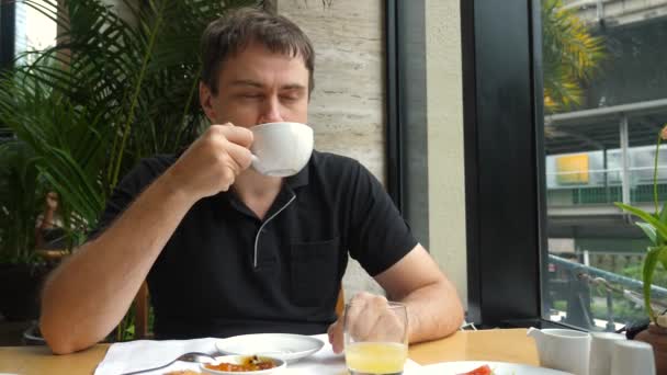Man on breakfast in luxury restaurant, drinking and enjoy hot cappuccino coffee — Stock Video