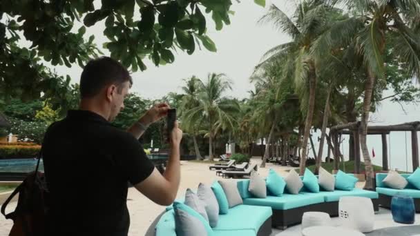 Travel man with backpack on beach with pals recording video for social media — Stock Video