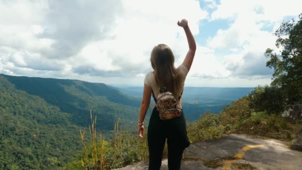 Młoda, odnosząca sukcesy kobieta podnosząca ręce, stojąca na szczycie góry — Wideo stockowe