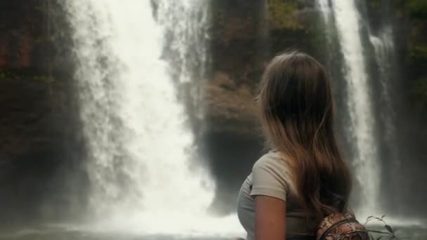 Vrouwelijke backpacker toerist op zoek naar geweldige waterval in jungles, vakantie reis — Stockvideo
