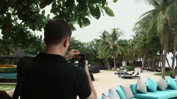 Podróżnik z plecakiem na plaży z palmami nagrywanie wideo dla mediów społecznościowych — Wideo stockowe